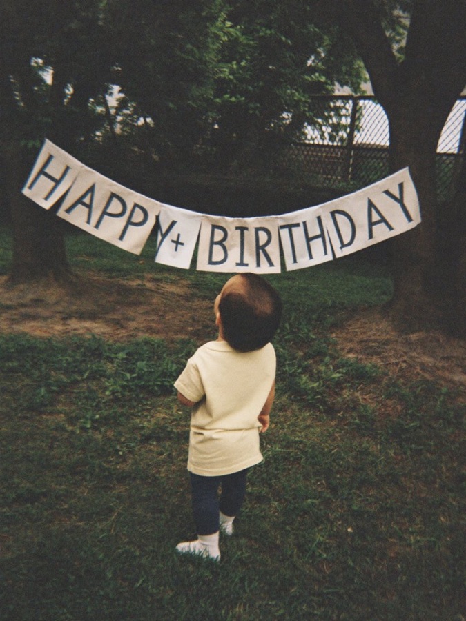 생일 현수막 아래 선 아이
